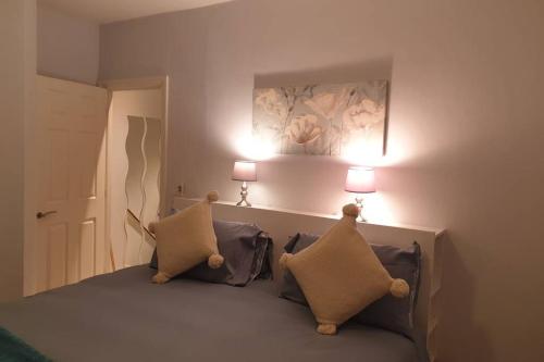 een slaapkamer met een bed met twee lampen aan de muur bij Spacious 2 bed in gated community up to 6 guests in Londen