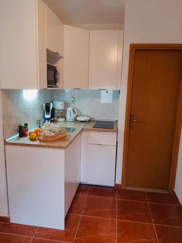 a kitchen with white cabinets and a counter top at Apartments Barbaresko in Lumbarda
