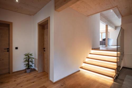 a staircase in a house with white walls and wooden floors at Alpenchalet "DAHOAM" in Going