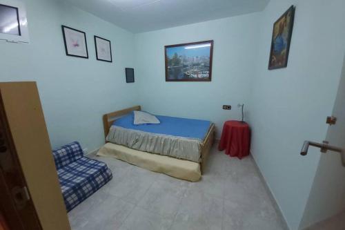 a small bedroom with a bed and a chair at Kal massis in Pinell de Bray