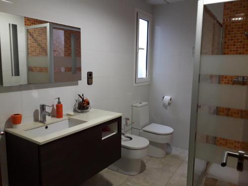 a white bathroom with a toilet and a sink at Kal massis in Pinell de Bray