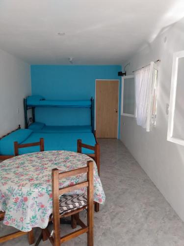 a room with a table and chairs and a bed at Atardecer Serrano in Huerta Grande