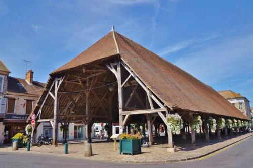 a large building with a roof on a street at Studio POP DESIGN in Milly-la-Forêt