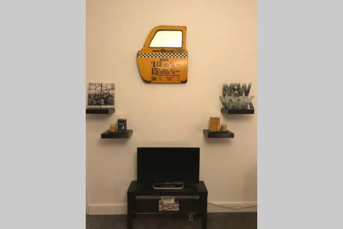a wall with a tote bag and a table at Studio POP DESIGN in Milly-la-Forêt