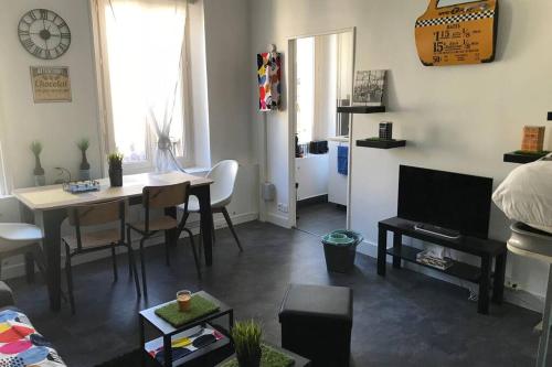 a living room with a table and a dining room at Studio POP DESIGN in Milly-la-Forêt