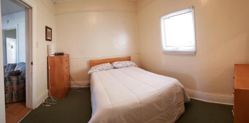 a small bedroom with a bed and a window at Vacation Cottage in Canora