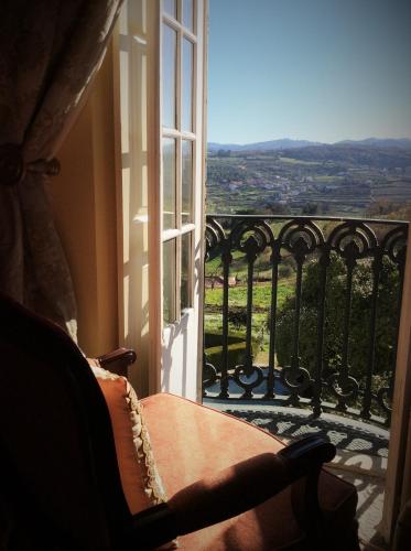 a window with a chair looking out at a view at Hotel Rural Casa dos Viscondes da Varzea in Lamego