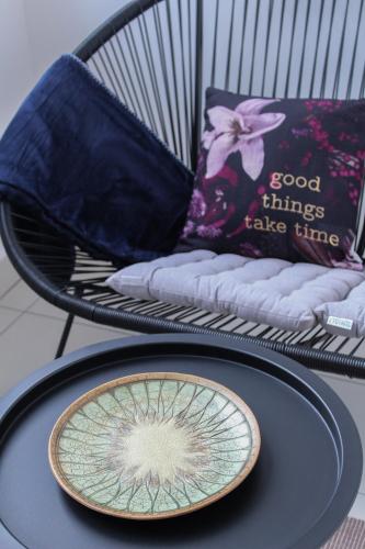 a plate on a table next to a chair at Bright, modern & cozy apartment in Tuzla