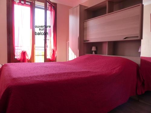 a bedroom with a red bed and a window at Les Cèdres in Ax-les-Thermes