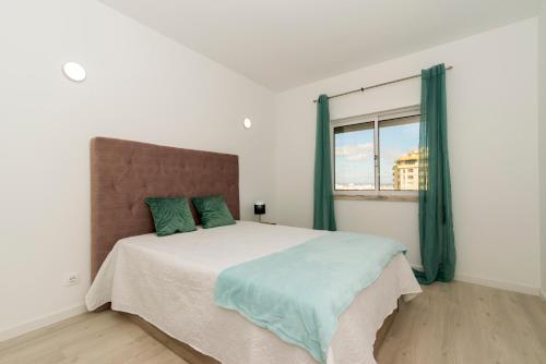 a bedroom with a large bed with a window at Casa do Barco, Vista Praia Armação Pêra in Armação de Pêra