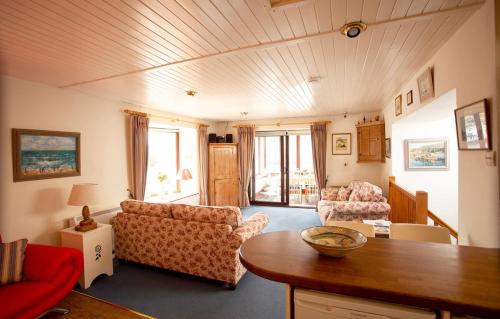 a living room with a couch and a table at Tabs Cottage in Fowey