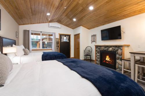 a bedroom with two beds and a fireplace at Woodland Inns in Forks