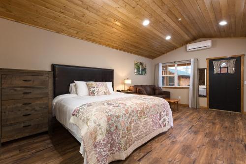 a bedroom with a bed and a wooden ceiling at Woodland Inns in Forks