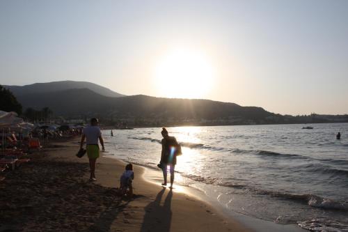 a group of people walking on the beach at Blue View Villas in Stalida