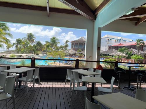 a restaurant with tables and chairs and a view of the beach at PETIT COIN DE PARADIS in Saint-François