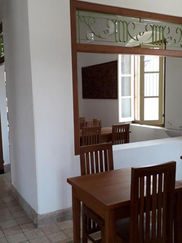 una sala da pranzo con tavolo e sedie in legno di iLOMBA a Probolinggo