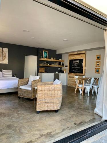 a living room with a bed and chairs and a table at Lower Point Surf Studio 2 in Jeffreys Bay