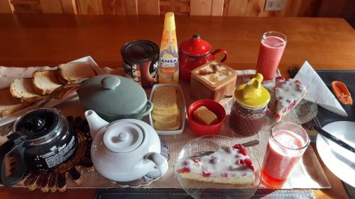 een tafel met een theepot, brood en kruiden bij Casa Tregül B&B in Villarrica