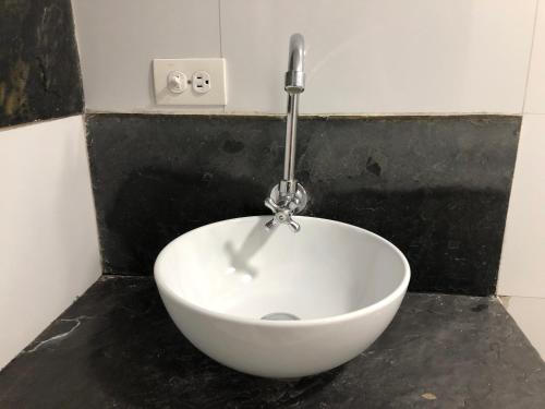 a white bowl sitting on a counter in a bathroom at ESTAR AQUI Bogotá in Bogotá