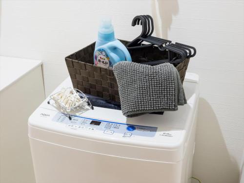 a basket on top of a toilet with a bottle of soap at COTO Tokyo Shibuya 8 in Tokyo