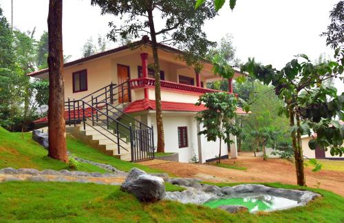 a house with a pond in front of it at Green Garden Holiday Home Wayanad in Vythiri