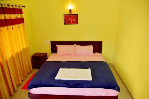 a bedroom with a bed with pink and blue at Green Garden Holiday Home Wayanad in Vythiri