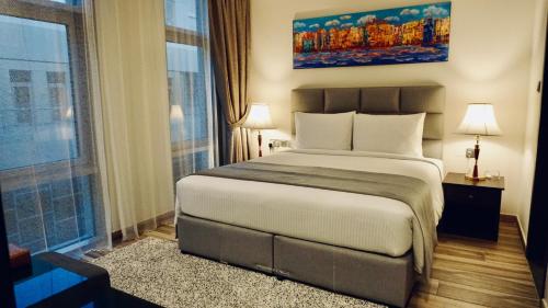 a bedroom with a large bed and a large window at Al Kout Beach Hotel in Kuwait