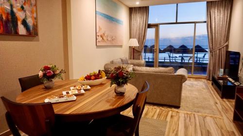 a living room with a wooden table and a living room at Al Kout Beach Hotel in Kuwait