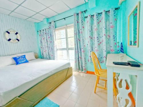 a bedroom with a bed and a desk and a window at Sweet Home at Sattahip in Sattahip