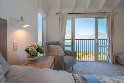 a bedroom with a bed and a couch and a window at The Alpine Way Queenstown in Queenstown