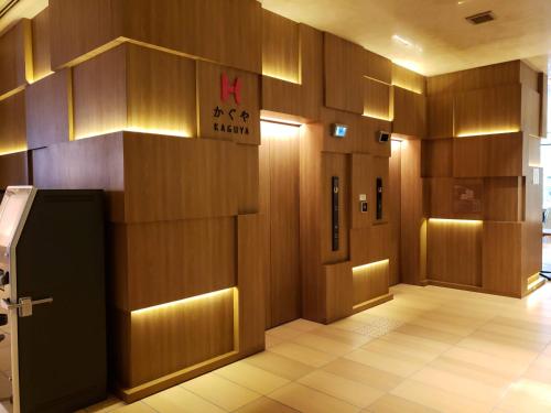 a lobby with wooden walls and a sign on the wall at Royal Twin Hotel Kyoto Hachijoguchi in Kyoto