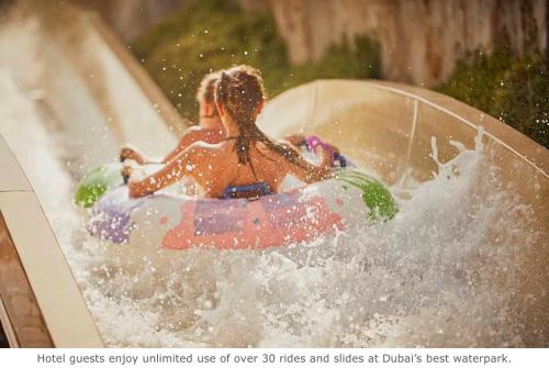 a girl riding a wave on top of a surfboard at Jumeirah Mina A'Salam in Dubai