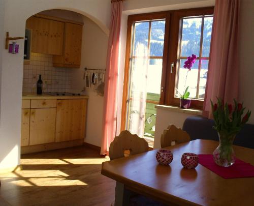 eine Küche mit einem Tisch und einem großen Fenster in der Unterkunft Landhaus Hirterhütte in Abtenau