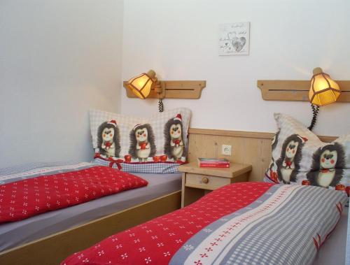 2 Einzelbetten in einem Zimmer mit roten Kissen in der Unterkunft Landhaus Hirterhütte in Abtenau