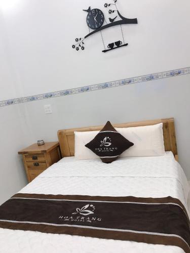 a bedroom with a bed with a clock on the wall at Hoa Trang Hotel in Tuy An
