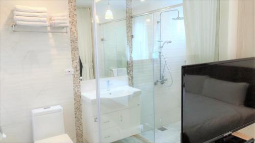 a bathroom with a glass shower and a sink at Taitung Z. Hotel in Taitung City