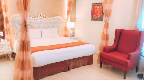 a bedroom with a bed and a red chair at Taitung Z. Hotel in Taitung City