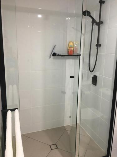 un bagno con doccia con porta in vetro di BEACH Luxury Upmarket 2B 2B OCEAN VIEWS 250m to BUDDINA BEACH! a Buddina