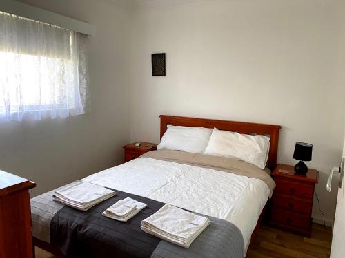 1 dormitorio con 1 cama con 2 toallas en Waldeck Heights, en Geraldton