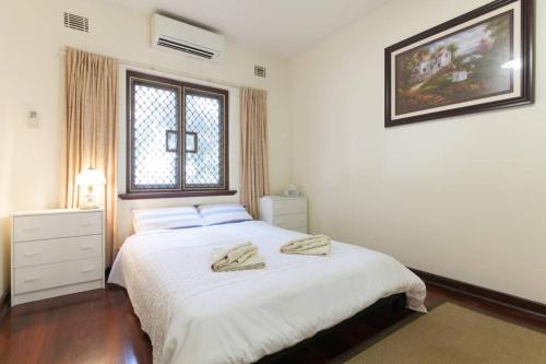 a bedroom with a white bed with two towels on it at B2 Crawley Apartment 1 BRM & Sleepout near UWA in Perth