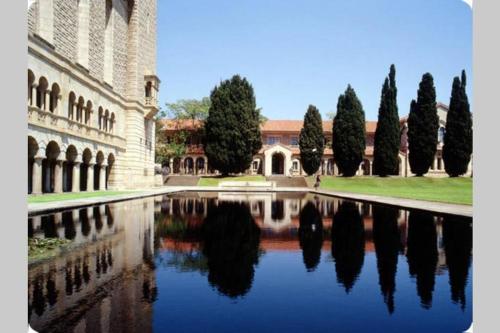 a building with trees and a reflection in a pool of water at B2 Crawley Apartment 1 BRM & Sleepout near UWA in Perth