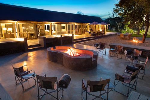 a patio with a fire pit and tables and chairs at Die Boskamp Self-Catering Bush Retreat in Marble Hall