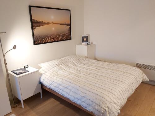 een slaapkamer met een bed en een foto aan de muur bij Ostend Sea Paradise in Oostende