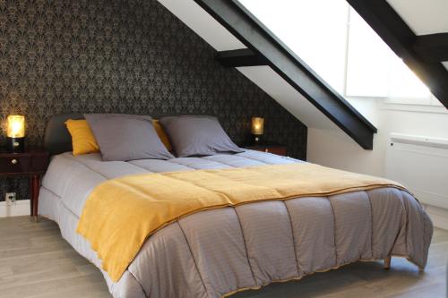 um quarto com uma cama grande e um cobertor amarelo em PYRENE HOLIDAYS 4 étoiles spacieux dans immeuble atypique proche des thermes et des Pyrénées em Capvern