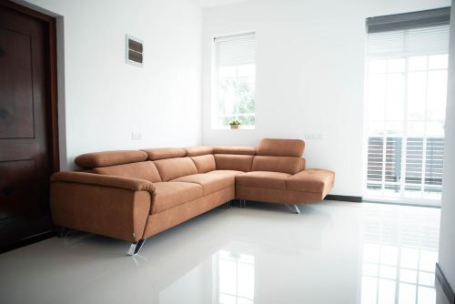 a brown couch sitting in a living room at White Castle in Wadduwa
