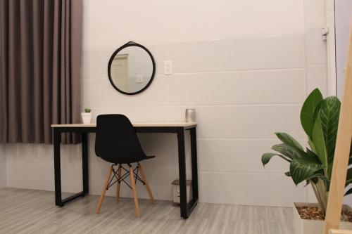 a black desk with a black chair and a mirror at B Home in Can Tho