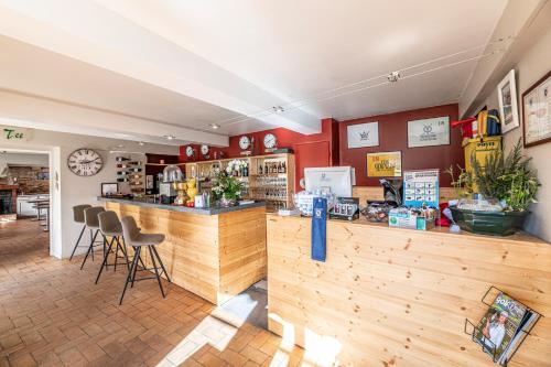 a restaurant with a counter and chairs in a room at Hotel Helios - Golf in Salies-de-Béarn