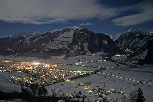 a town in the snow at night with a mountain at Appartements Wallner in Uttendorf