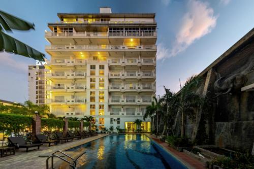 un hôtel avec une piscine en face d'un bâtiment dans l'établissement Aristocrat Residence & Hotel, à Sihanoukville