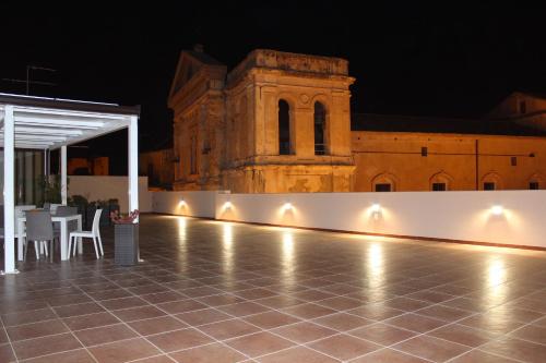a patio at night with a building in the background at Case Vacanze Al Duomo in Licata